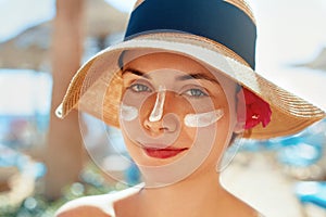 Facial Care. Female Applying Sun Cream and Smiling. Beauty Face. Portrait Of Young Woman Smear Moisturizing Lotion on Skin.