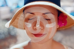 Facial Care. Female Applying Sun Cream and Smiling. Beauty Face.  Portrait Of Young Woman Smear  Moisturizing Lotion on Skin.