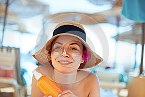 Facial Care. Young Female Holding Bottle Sun Cream and Applying on Face Smiling. Beauty Face.