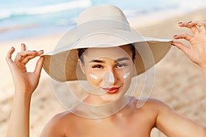 Facial Care. Young  Female Holding Bottle Sun Cream and  Applying on Face Smiling. Beauty Face.