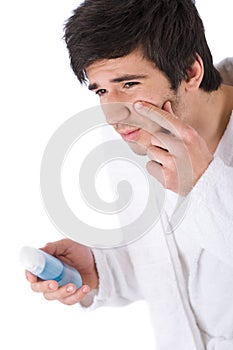 Facial care - Young man cleaning face with lotion