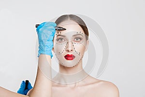 Facial cosmetic plastic surgery. Doctor surgeon hand in glove draw wrinkle lines on Woman face isolated white background.