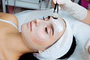 Facial cosmetic procedure in spa salon. The procedure for applying a mask to the