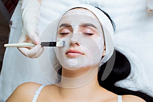 Facial cosmetic procedure in spa salon. The procedure for applying a mask to the