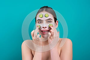 Facial mask of cucumber. Beautiful woman with facial mask with slices of fresh cucumber on face. Cosmetic masks on face