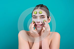 Facial mask of cucumber. Beautiful woman with facial mask with slices of fresh cucumber on face. Cosmetic masks on face