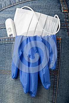 Facial mask, thermometer and latex glove in back pocket