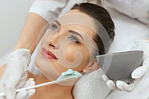 Facial Mask. Woman Applying Cosmetic Alginate Mask On Skin