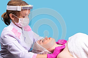 Facial massage for female patient in a beauty clinic. Concept of skin care, spa, beauty salon, treatment, masseuse