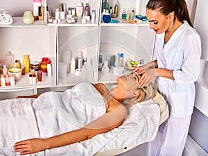 Facial massage for forty year old woman in spa salon.