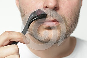 Facial massage with microneedle dermaroller for the treatment of scars, wrinkles and for beard growth.