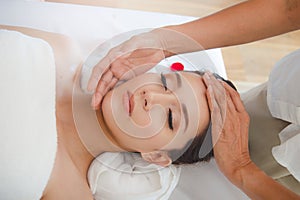 Facial massage in spa salon. Relaxation Beautiful woman lying on the bed and doing facial treatment in spa salon by masseur.