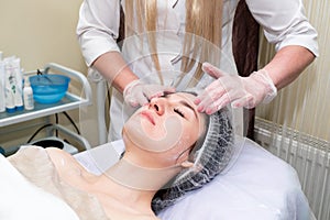 Facial massage. Young beautiful woman getting professional face treatment. Spa, resort, beauty and health concept