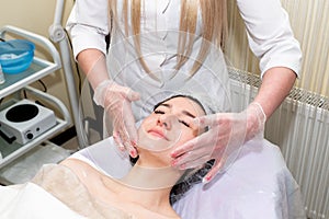 Facial massage. Young beautiful woman getting professional face treatment. Spa, resort, beauty and health concept