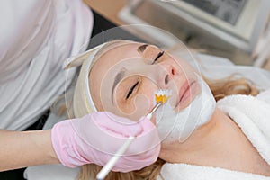 Facial peeling mask, beauty spa, skin care. Woman getting facial treatment