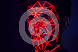 Facial Recognition Technology Concept As Man Has Red Grid Projected Onto Face In Studio photo
