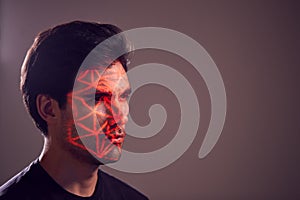 Facial Recognition Technology Concept As Man Has Red Grid Projected Onto Face In Studio photo