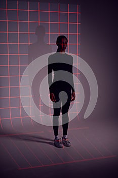 Facial Recognition Technology Concept As Woman Has Red Grid Projected Onto Body In Studio