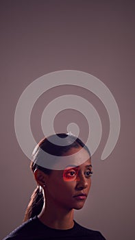Facial Recognition Technology Concept As Woman Has Red Grid Projected Onto Eye In Studio