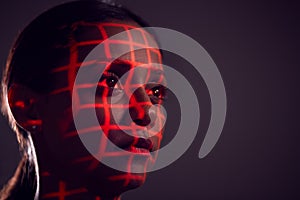 Facial Recognition Technology Concept As Woman Has Red Grid Projected Onto Face In Studio photo