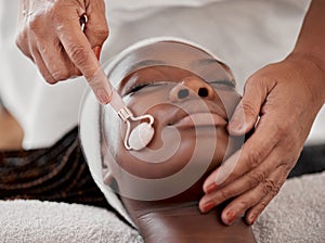 Facial roller, spa and black woman relax for massage, wellness and skincare cosmetics at salon. Beauty, face and