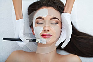 Facial Skin Care. Beautiful Woman Getting Cosmetic Mask In Salon