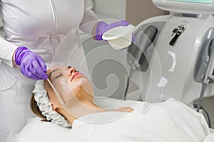 Facial skin care. A mask is applied to a woman`s face in a cosmetology clinic. Close up