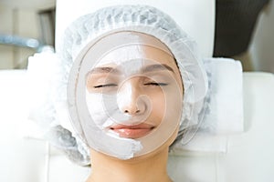 Facial skin care and protection. A young woman at a beautician& x27;s appointment. Portrait of a woman with a rejuvenating