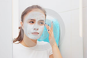 Facial skin care. Young girl makes a moisturizing cleansing face mask