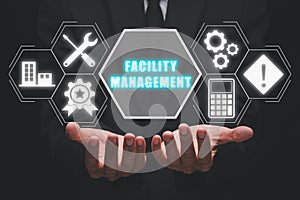 Business person hand holding facility management icon on virtual screen