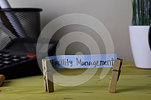 Facility Management. Handwriting on sticky notes in clothes pegs on wooden office desk