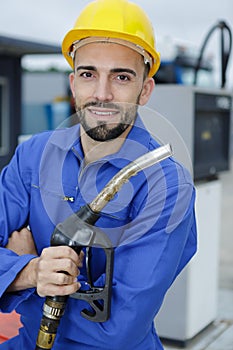 facility worker holding gas pump