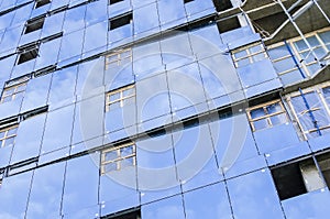 Facing the blue glass wall of the building