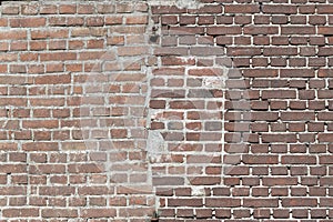 Facing bricks in a repaired wall in a dark red color in chain bond