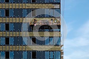 Facing the building with a ventilated facade and hoist with workers.