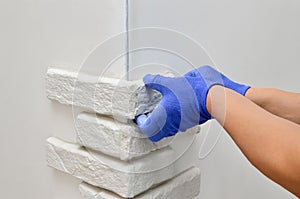 Facing wall decorative tiles, workers in blue glove