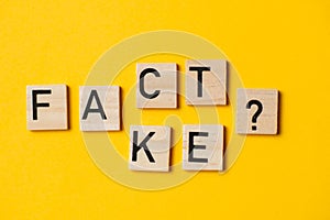 fact or fake words with a question on a yellow background