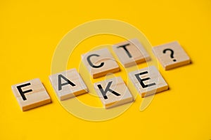 fact or fake words with a question on a yellow background