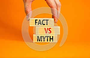 Fact vs myth symbol. Concept words Fact vs myth on wooden blocks on a beautiful orange table orange background. Businessman hand.