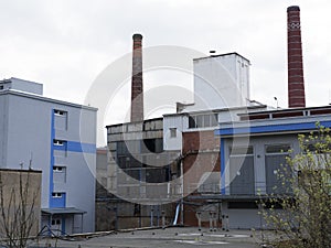 Factory building with water reservoir, chemical industry. Daylight, cloudy sky.