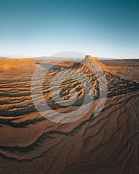 Factory Butte in the Caineville Badlands of Utah. Aerial drone panorama during sunrise.