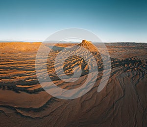 Factory Butte in the Caineville Badlands of Utah. Aerial drone panorama during sunrise.