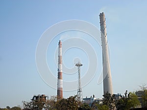 Factory chimney, industrial smoke chimneys, Tall industrial factory chimney smokestacks of jute mill industry in Ganges riverside