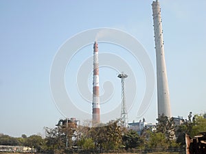 Factory chimney, industrial smoke chimneys, Tall industrial factory chimney smokestacks of jute mill industry in Ganges riverside