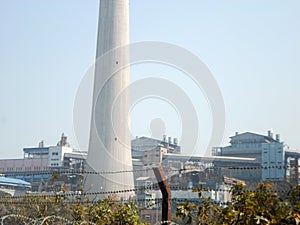Factory chimney, industrial smoke chimneys, Tall industrial factory chimney smokestacks of jute mill industry in Ganges riverside