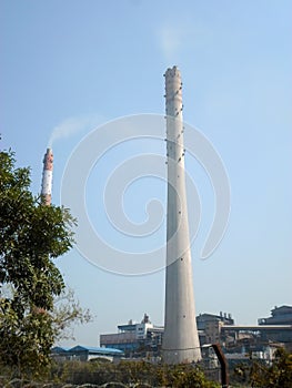 Factory chimney, industrial smoke chimneys, Tall industrial factory chimney smokestacks of jute mill industry in Ganges riverside