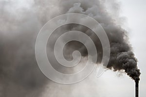 Factory chimney smoking, heavy black smoke on the sky.