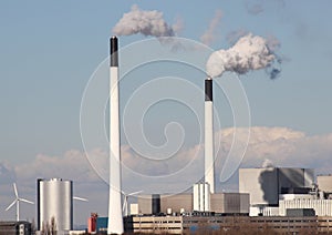 Factory chimneys with clouds and small windmills