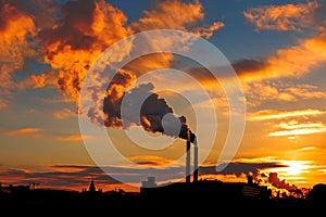 Factory chimneys smoke industrial building silhouette over Beautiful sunset