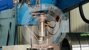 Factory employee operating process drilling metal on metalworking equipment